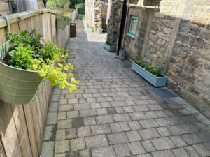 Hanging baskets and planters now flank the approach down into the sunshine and seclusion of the Secret Garden