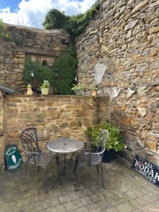 The courtyard section of the Secret Garden now features all manner of greenery from wild ivy colonising the old stone walls, to character filled pots of flowering plants and shrubs, sitting alongside some of the old signage we discovered from our buildings' previous lives.